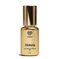 Gold bottle of 'Victoria' lash extension adhesive with 'LOVELY' branding on a white background